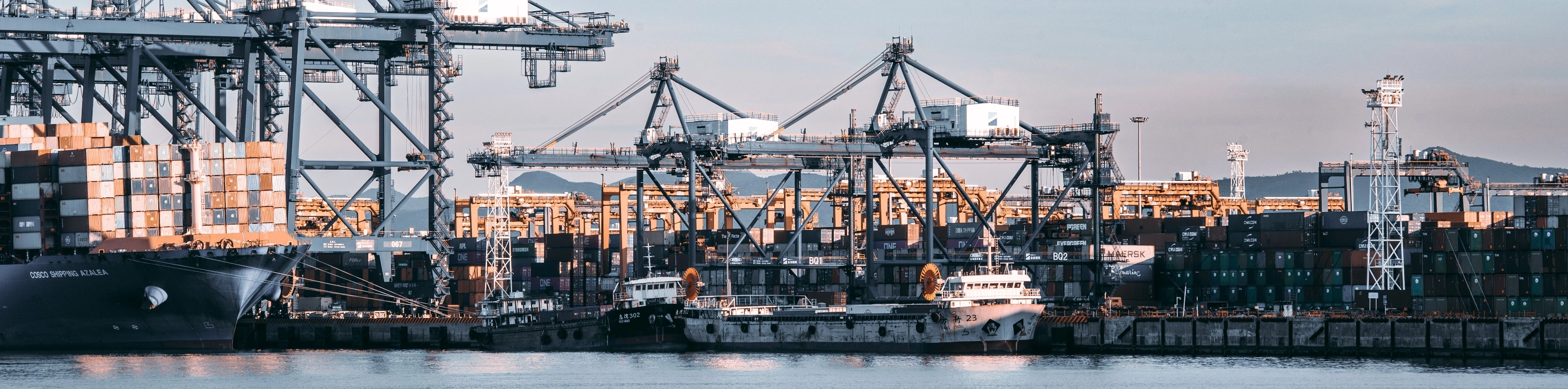 A large container ship is securely docked at a bustling port, ready for loading and unloading operations.