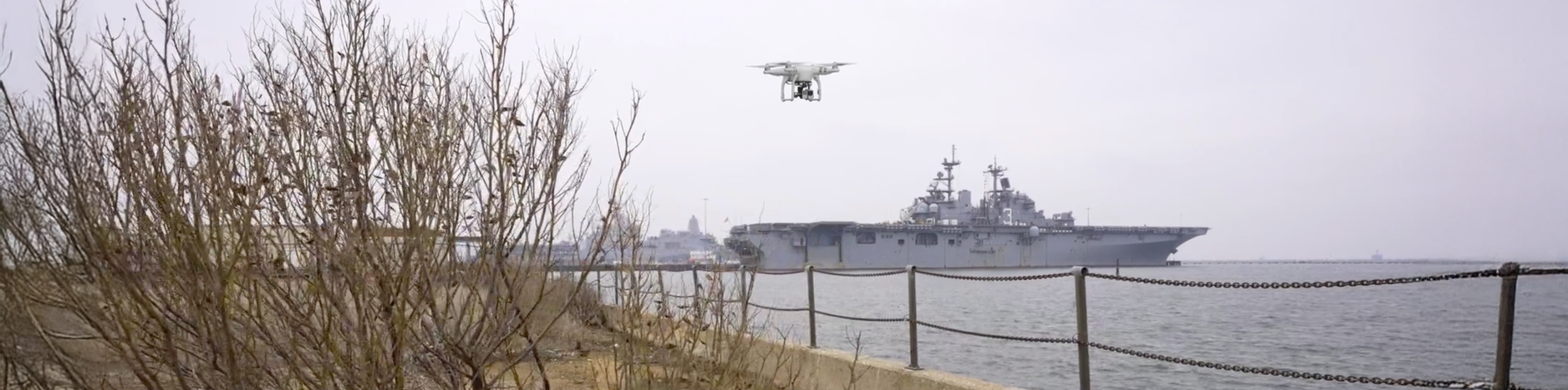 A drone above a ship navigating through the water, showcasing aerial technology in action.