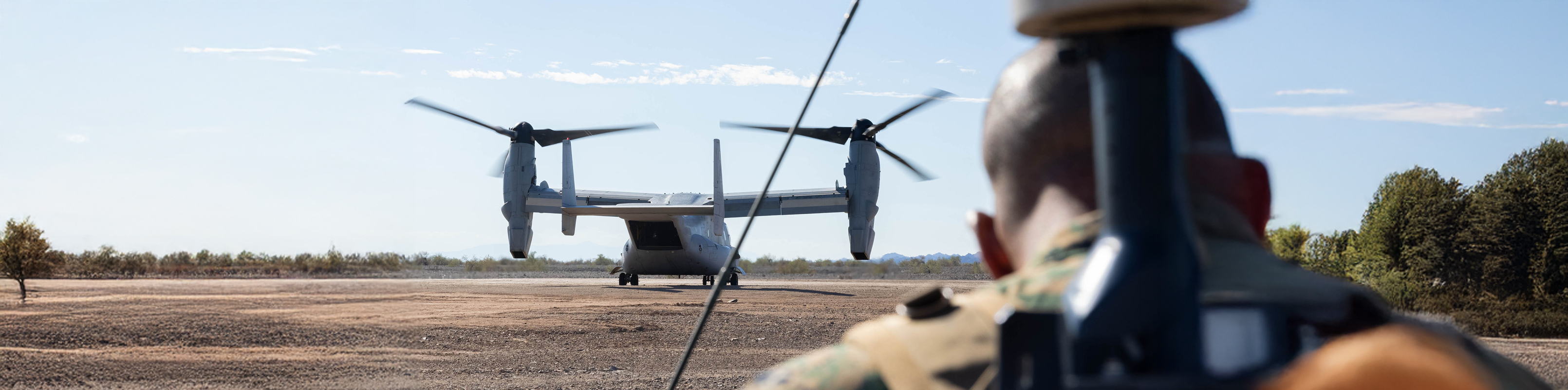 A man observes a plane parked on the ground, focusing intently on its details and surroundings.
